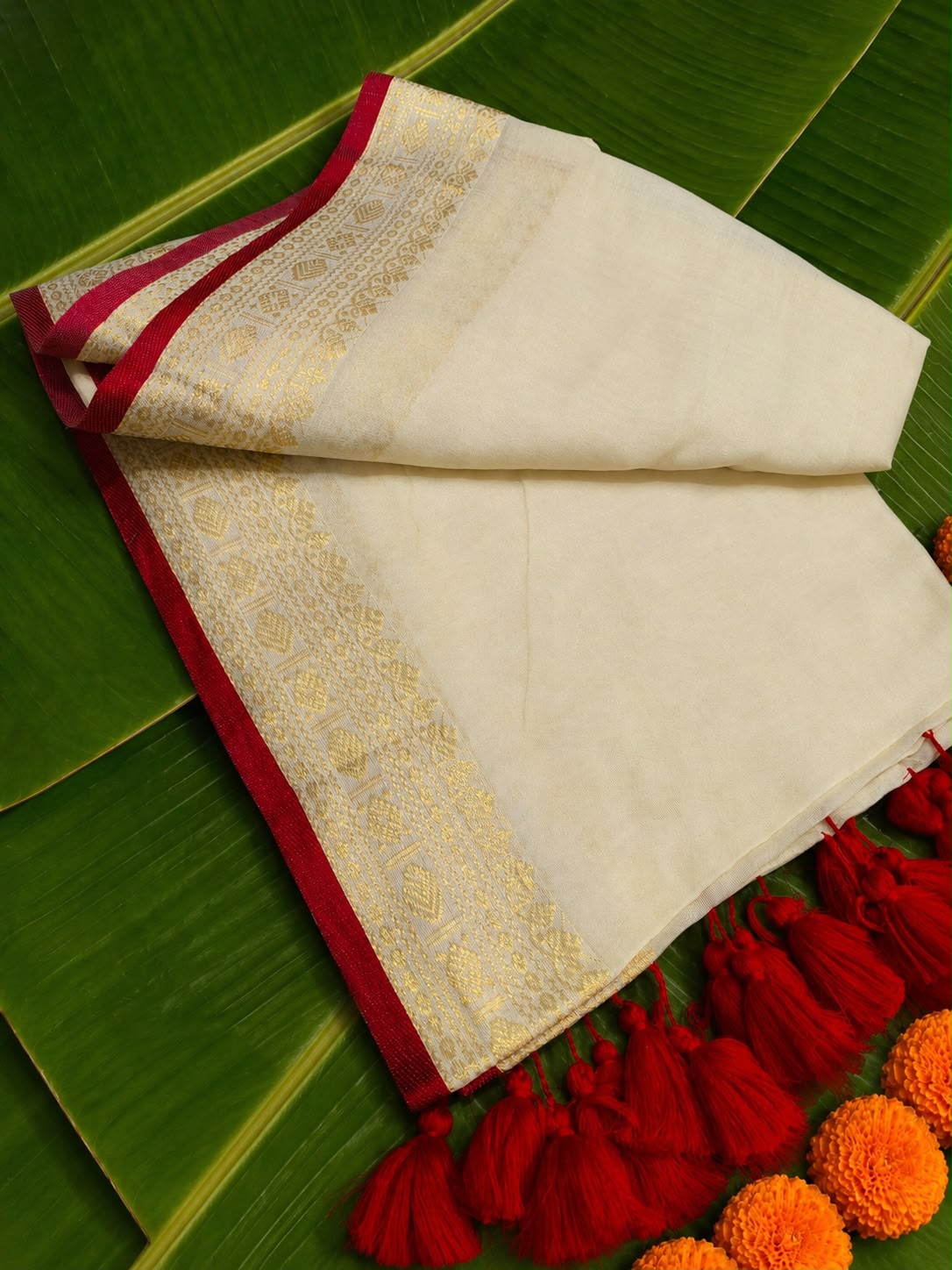 Anamika – Off-White Mul Cotton Saree with Rich Gold Zari Motif Border & Red Piping